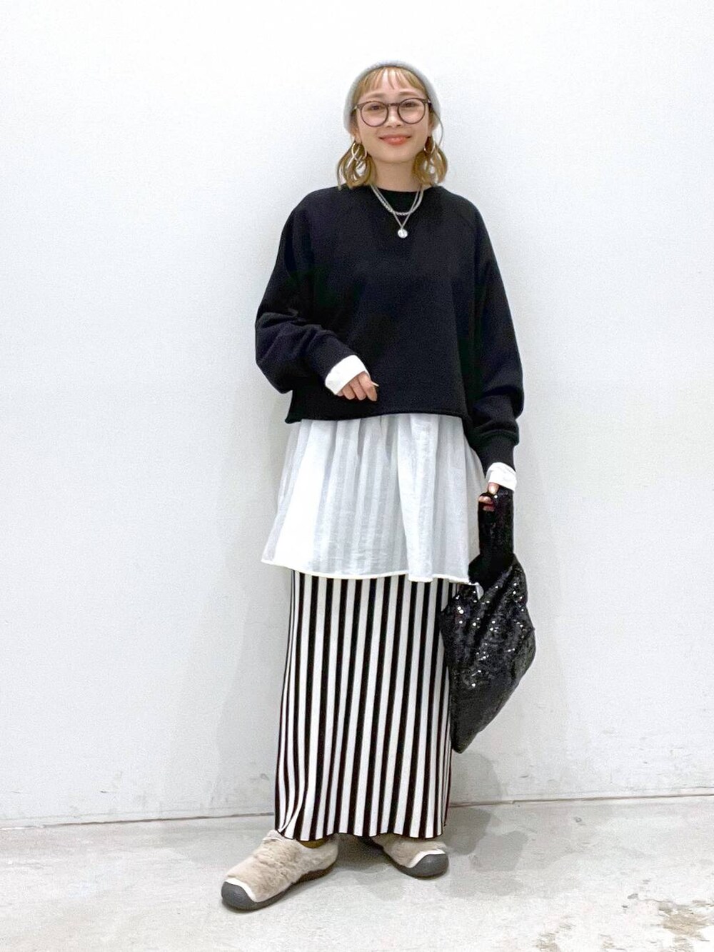 ブラック系のスカート、ブラック系のTシャツ/カットソー、ホワイト系のTシャツ/カットソーを着用したレディースの秋コーディネートの2枚目の写真