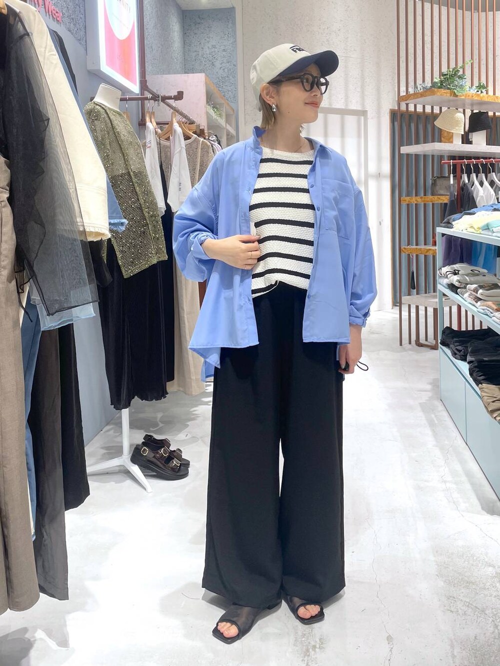 ホワイト系のニット/セーター、ブラック系のその他パンツ、ブルー系のシャツ/ブラウスを着用したレディースの春コーディネートの4枚目の写真