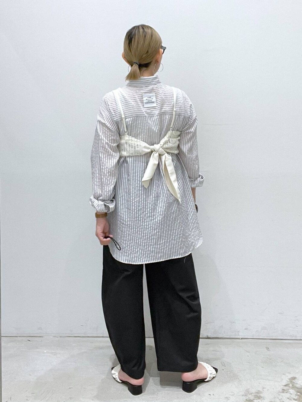 ブラック系のその他パンツ、ホワイト系のサンダル、ホワイト系のキャミソールを着用したレディースの夏コーディネートの3枚目の写真