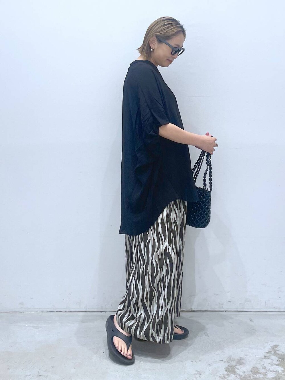 ブルー系のTシャツ/カットソー、ブラック系のハンドバッグ、ブラック系のチュニックを着用したレディースの夏コーディネートの3枚目の写真