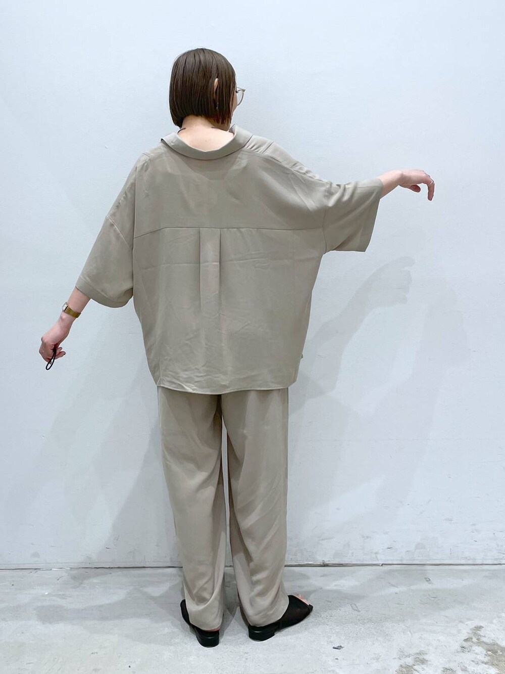 ベージュ系のその他パンツ、ホワイト系のタンクトップ、ブラック系のサンダルを着用したレディースの春コーディネートの3枚目の写真