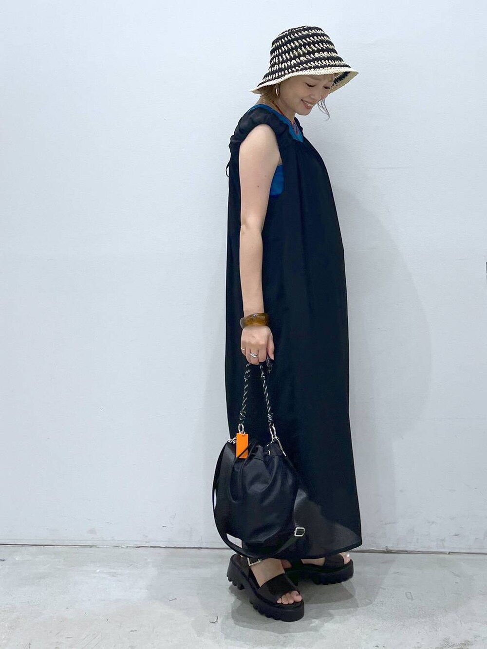 ブルー系のTシャツ/カットソー、ブラウン系のサンダル、ブラック系のショルダーバッグを着用したレディースの夏コーディネートの2枚目の写真