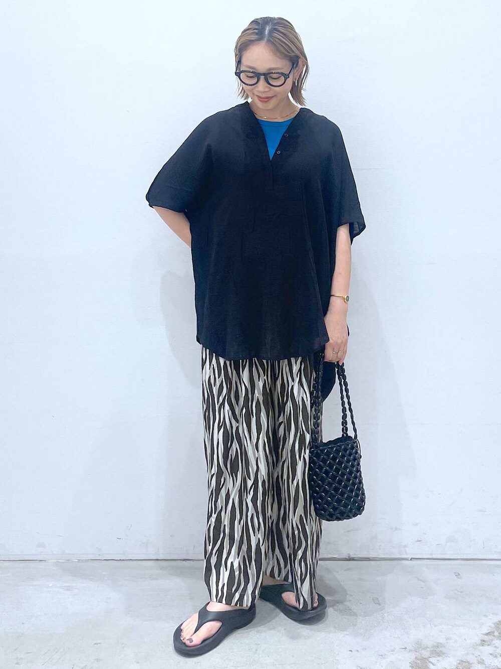 ブルー系のTシャツ/カットソー、ブラック系のハンドバッグ、ブラック系のチュニックを着用したレディースの夏コーディネートの2枚目の写真