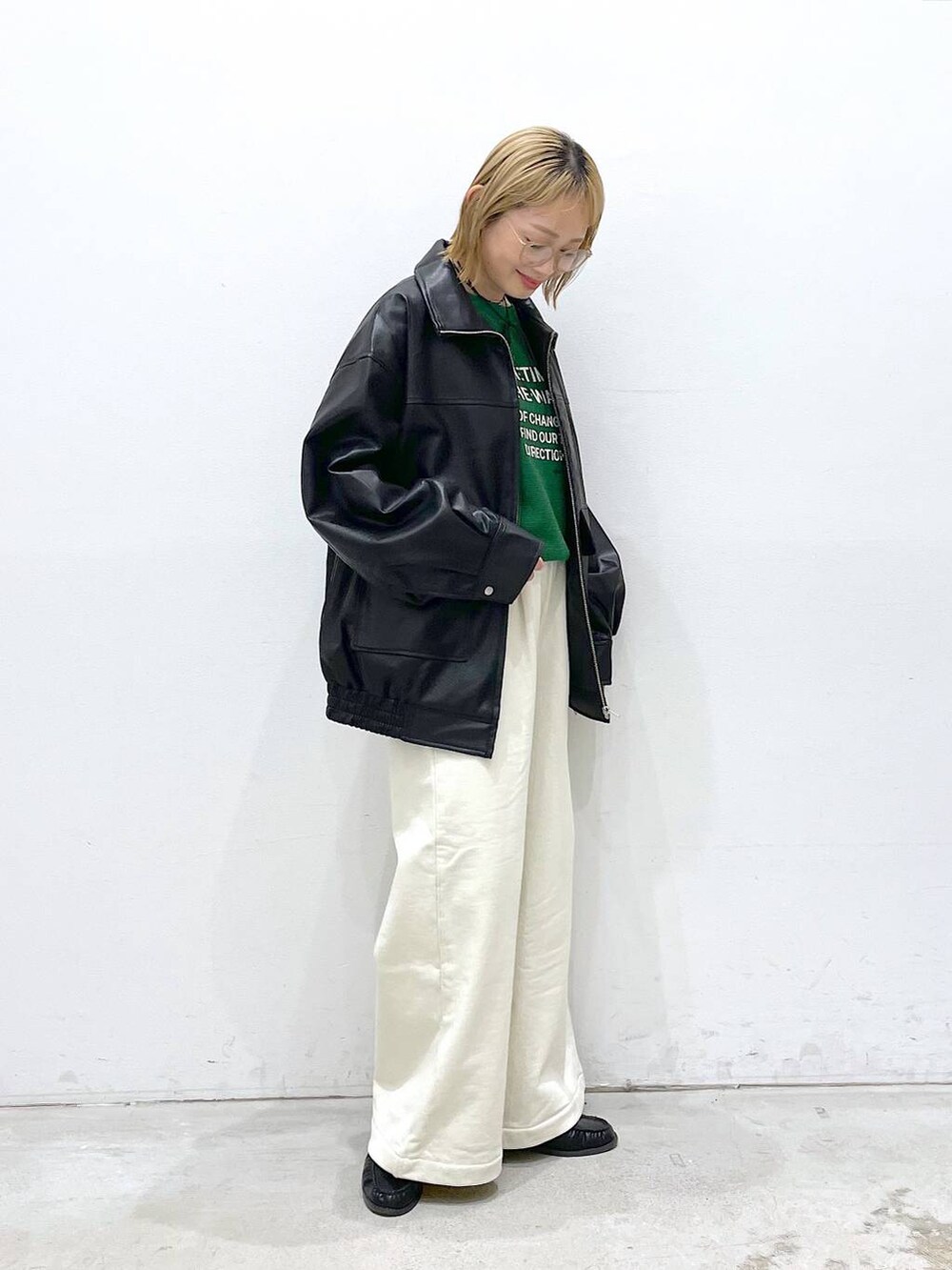 ブラック系のローファー、ブラック系のブルゾン、グリーン系のニット/セーターを着用したレディースの冬コーディネートの2枚目の写真