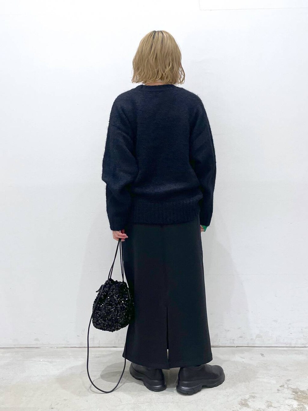 ブラック系のショルダーバッグ、ブラック系のスカート、ブラック系のTシャツ/カットソーを着用したレディースの冬コーディネートの3枚目の写真