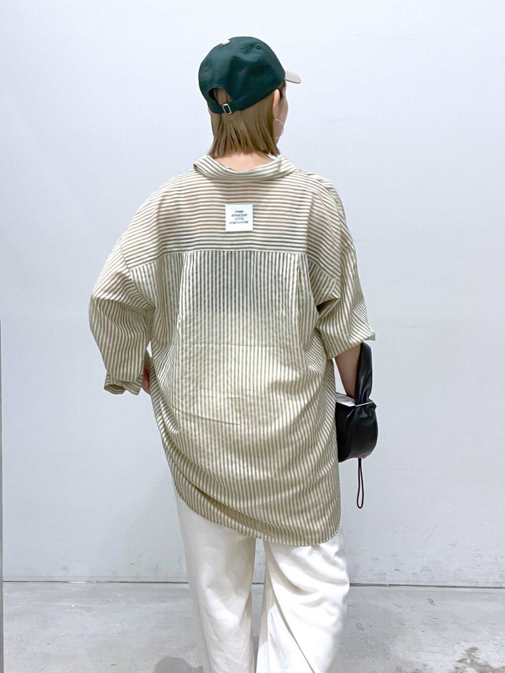 ホワイト系のその他パンツ、ブラック系のハンドバッグ、ブラック系のサンダルを着用したレディースの夏コーディネートの3枚目の写真