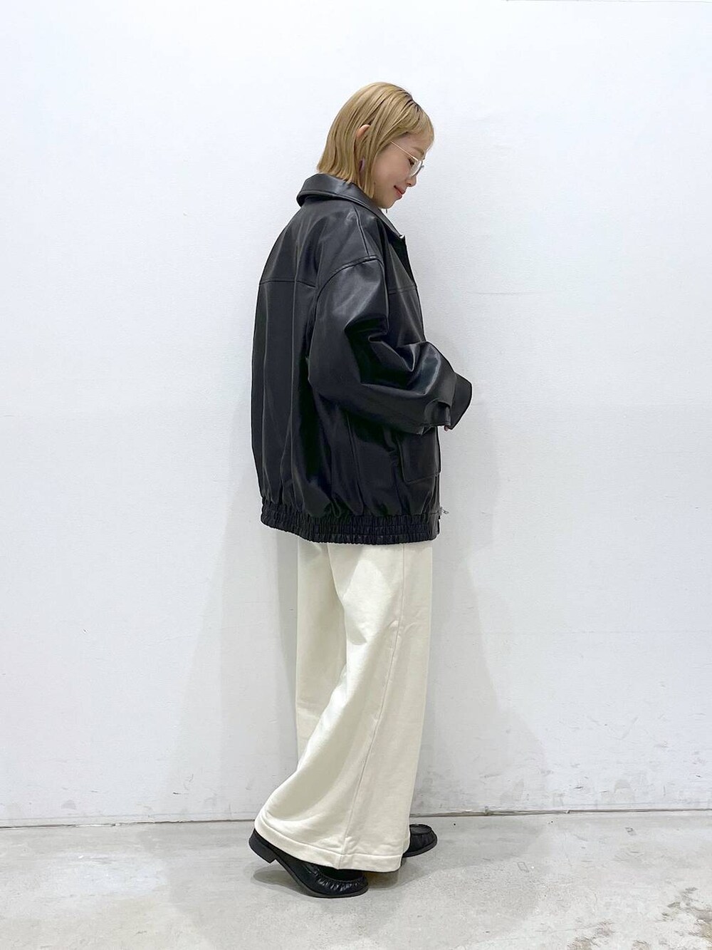 ブラック系のローファー、ブラック系のブルゾン、グリーン系のニット/セーターを着用したレディースの冬コーディネートの3枚目の写真