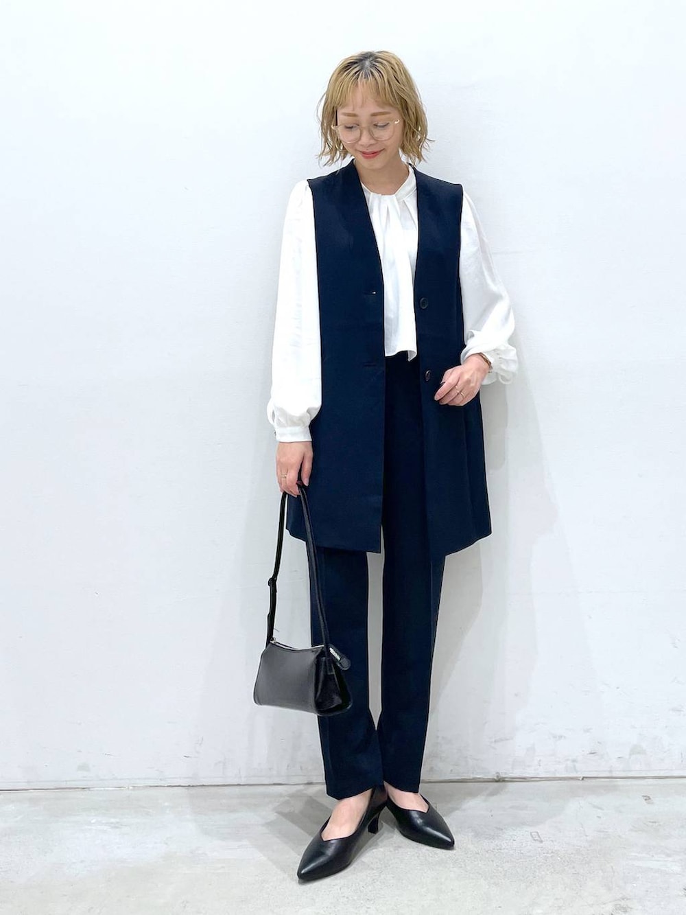 ブルー系のスーツパンツ、ホワイト系のシャツ/ブラウス、ブルー系のスーツベストを着用したレディースの冬コーディネートの4枚目の写真