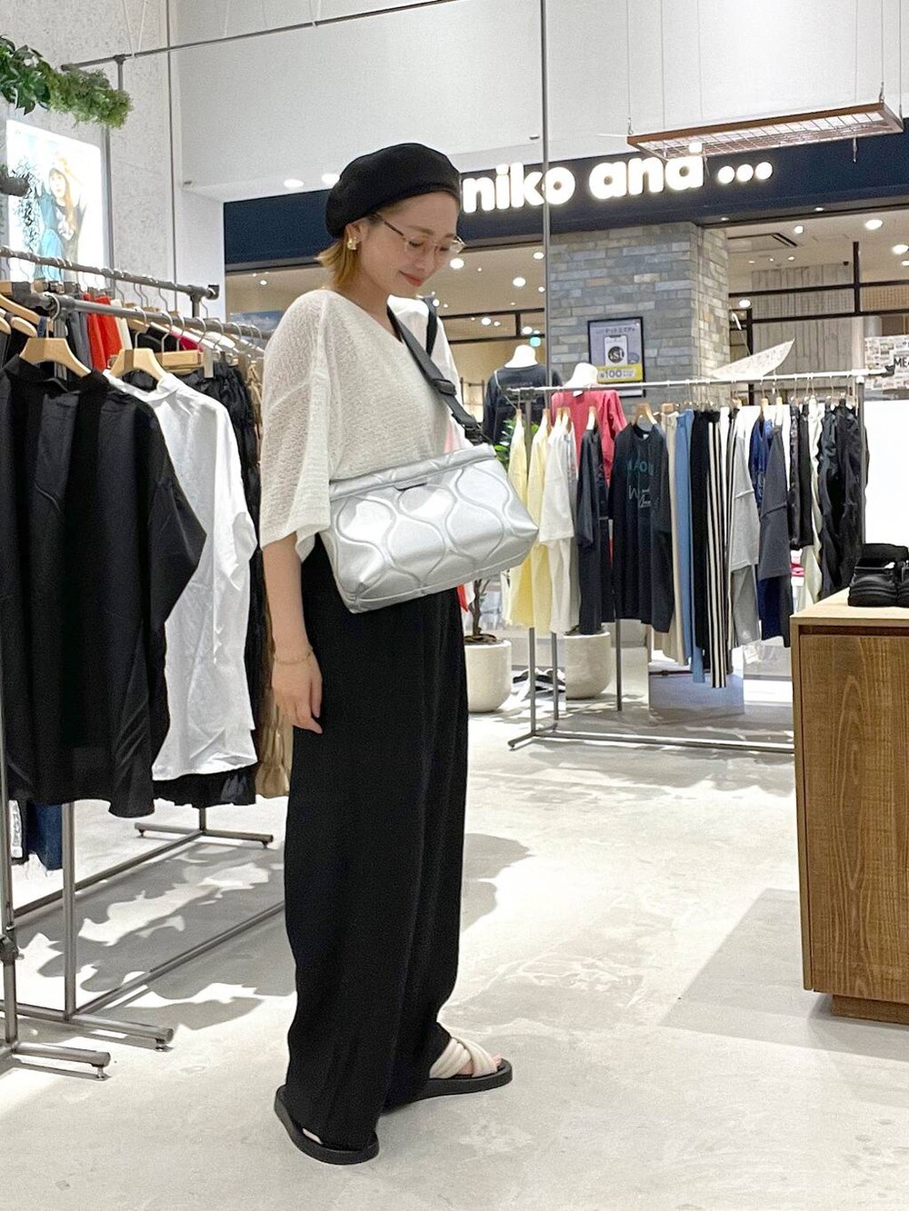 ブラック系のその他パンツ、ホワイト系のサンダル、シルバー系のクラッチバッグを着用したレディースの夏コーディネートの2枚目の写真