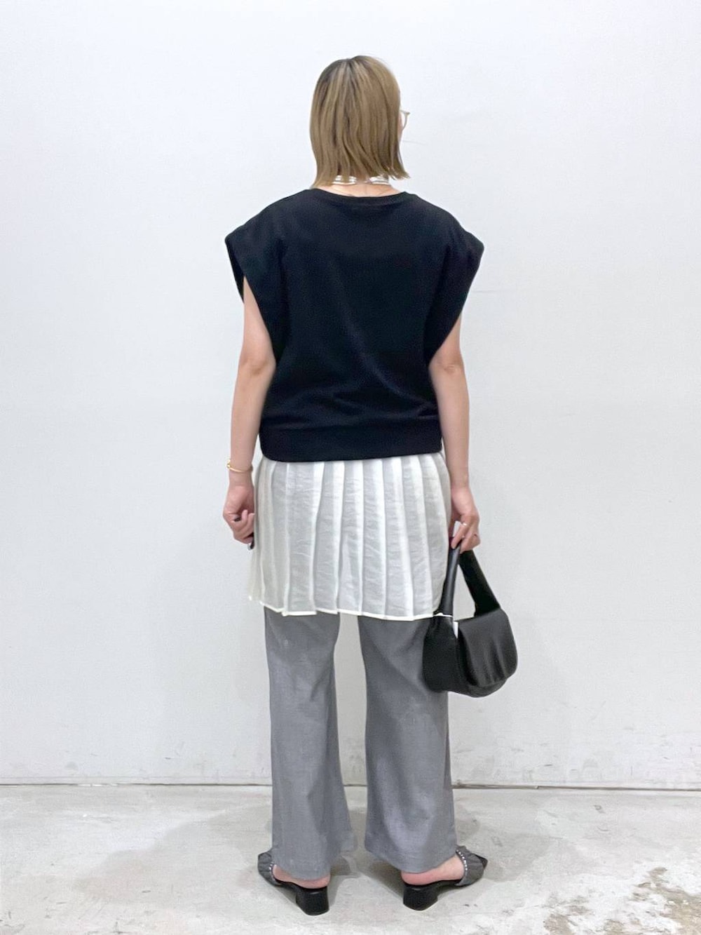 ブラック系のハンドバッグ、グレー系のその他パンツ、シルバー系のサンダルを着用したレディースの夏コーディネートの3枚目の写真