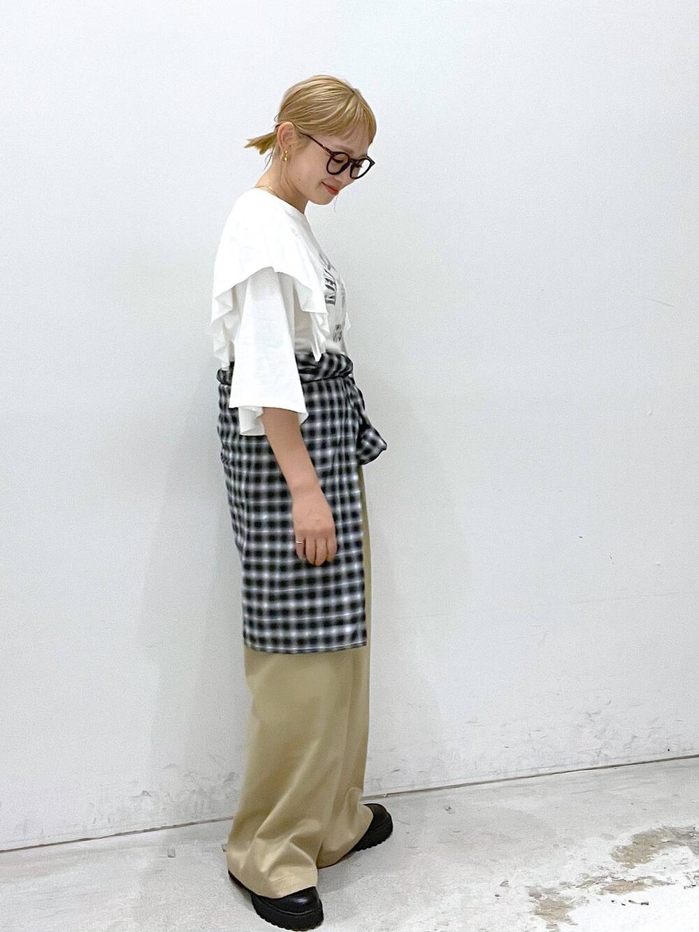 ベージュ系のチノパンツ、ブラック系のローファー、ホワイト系のTシャツ/カットソーを着用したレディースの夏コーディネートの2枚目の写真