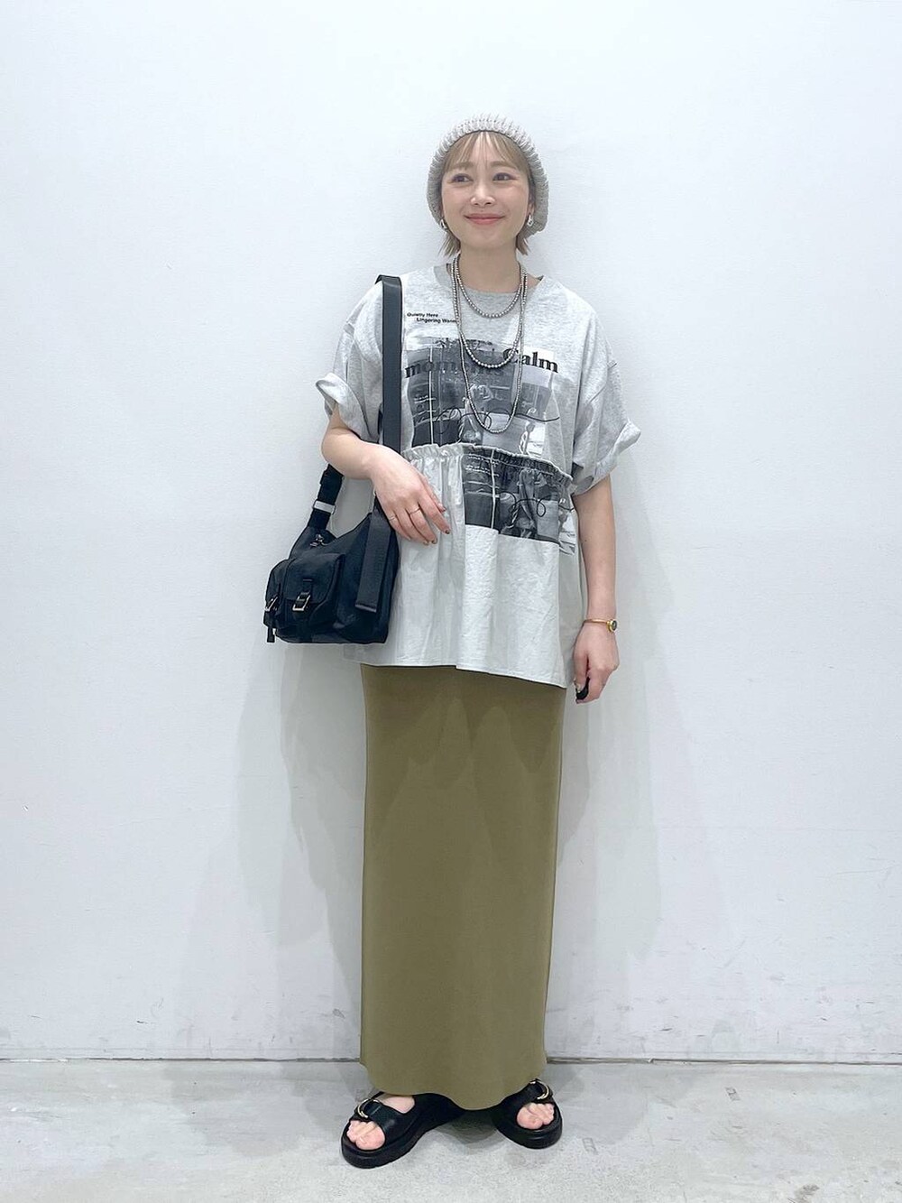 グリーン系のスカート、ブラック系のショルダーバッグ、ブラック系のサンダルを着用したレディースの春コーディネートの4枚目の写真