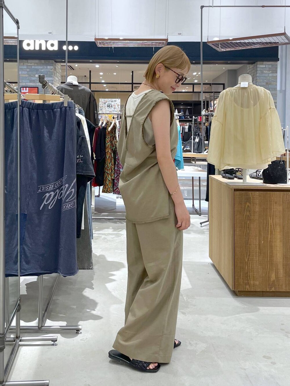 グリーン系のベスト、ホワイト系のタンクトップ、グリーン系のその他パンツを着用したレディースの夏コーディネートの2枚目の写真