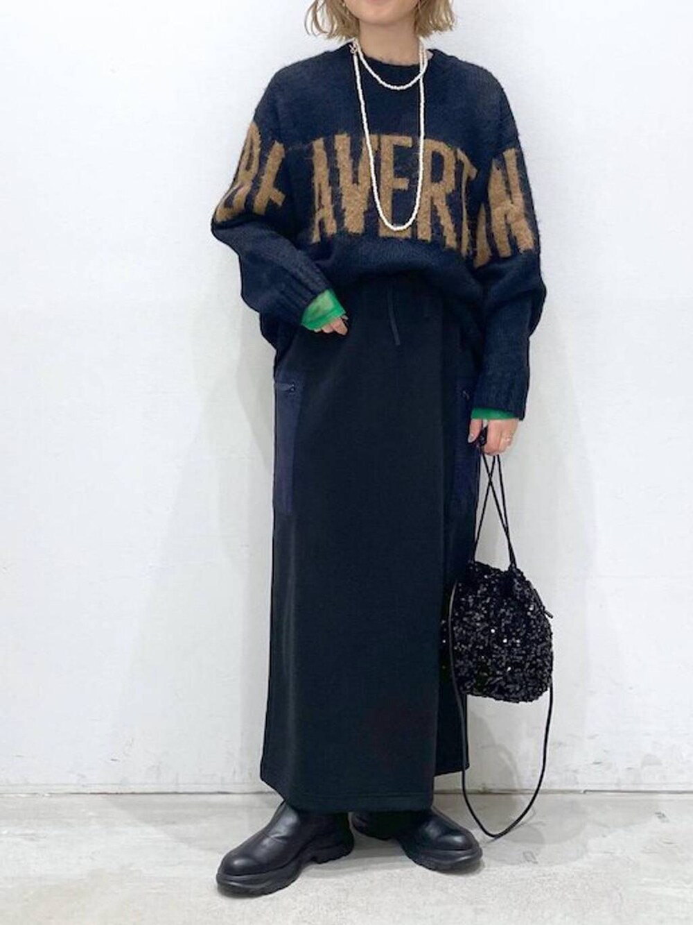 ブラック系のショルダーバッグ、ブラック系のスカート、ブラック系のTシャツ/カットソーを着用したレディースの冬コーディネートの4枚目の写真