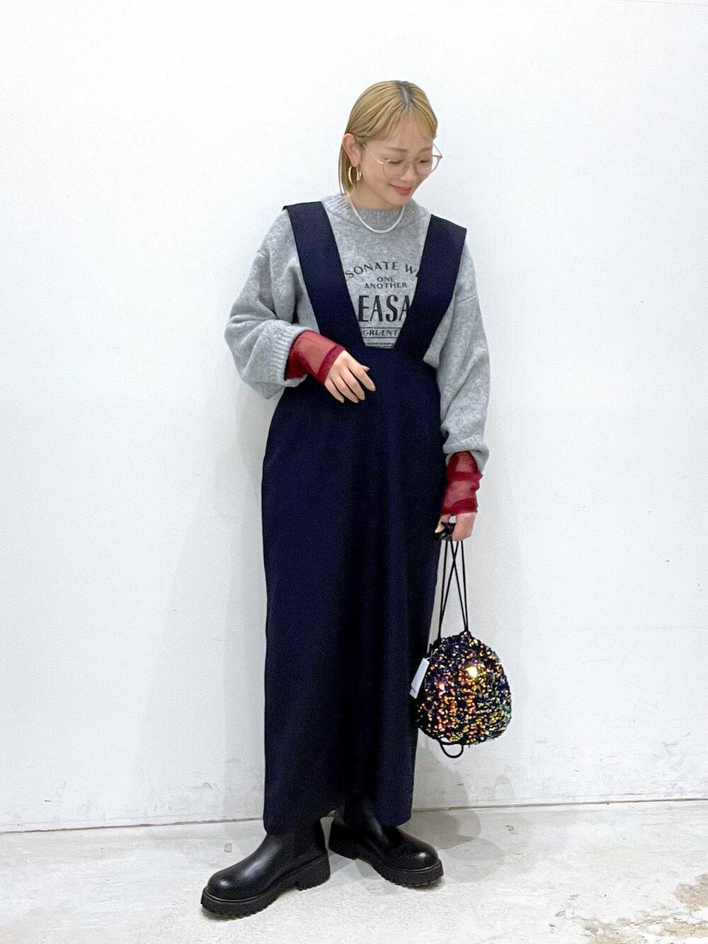 ブルー系のショルダーバッグ、ブラック系のTシャツ/カットソー、ブラック系のブーツを着用したレディースの冬コーディネートの4枚目の写真