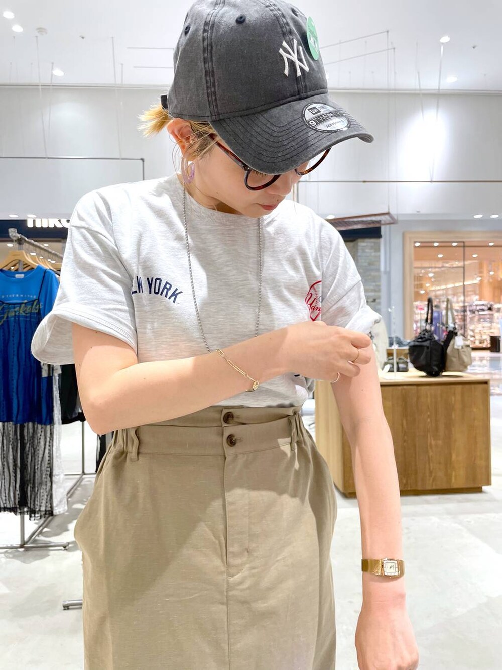 ブラック系のサンダル、ベージュ系のTシャツ/カットソー、グリーン系のスカートを着用したレディースの夏コーディネートの5枚目の写真
