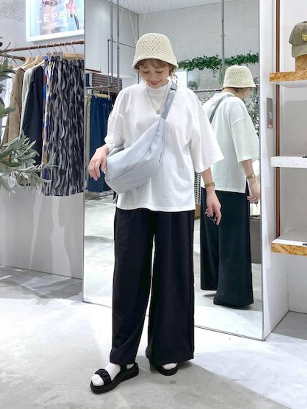 ホワイト系のTシャツ/カットソー、ブラック系のサンダル、ブラック系のその他パンツを着用したレディースの春コーディネートの4枚目の写真