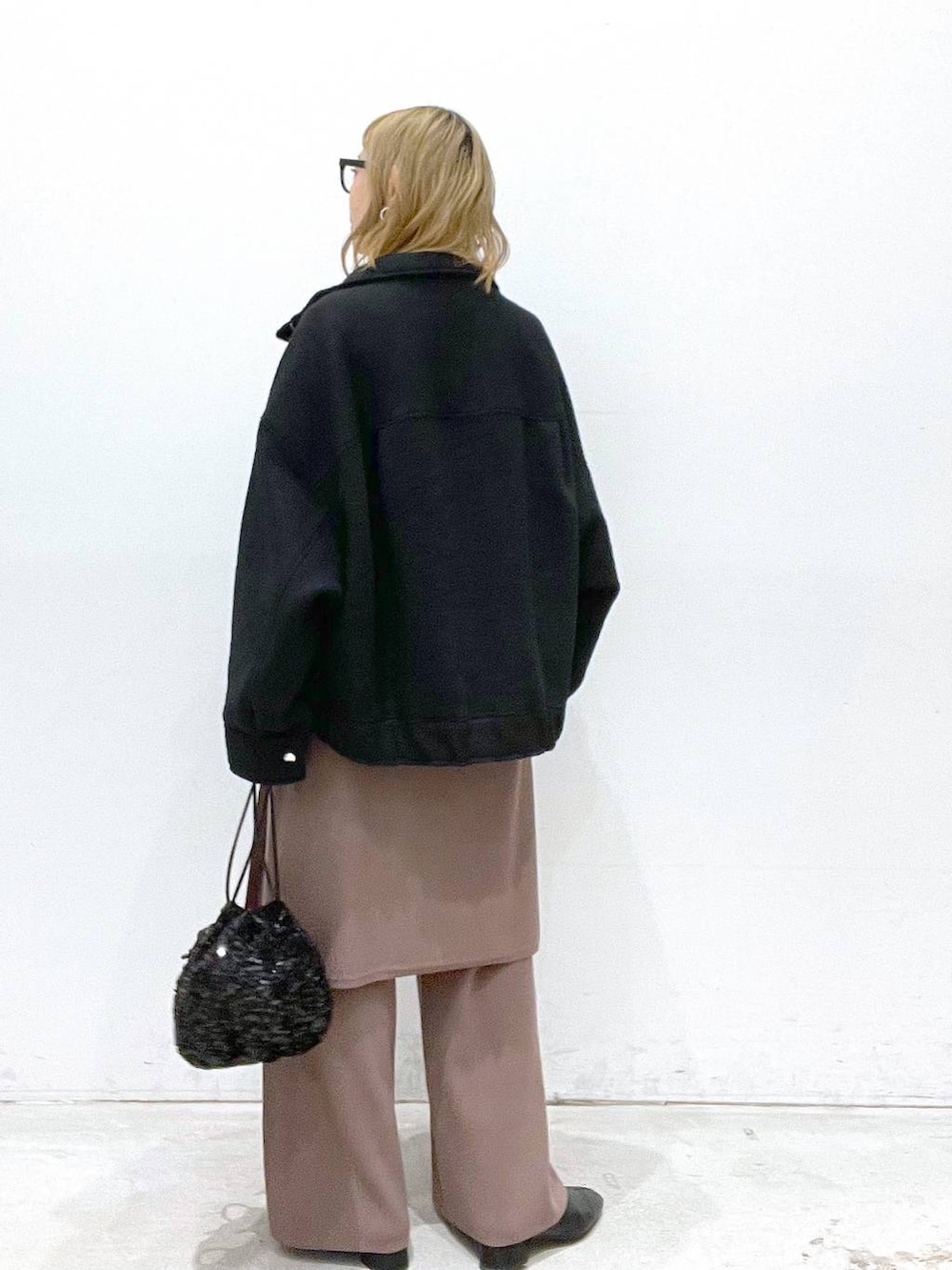 ブラック系のブルゾン、ブラウン系のその他パンツ、ブラック系のショルダーバッグを着用したレディースの秋コーディネートの3枚目の写真