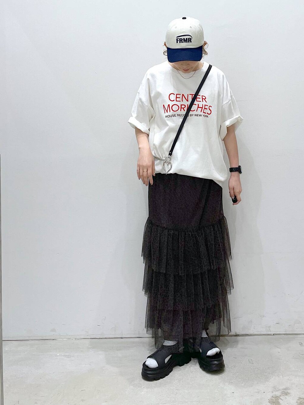 ブラック系のサンダル、ベージュ系のスカート、ホワイト系のTシャツ/カットソーを着用したレディースの春コーディネートの4枚目の写真