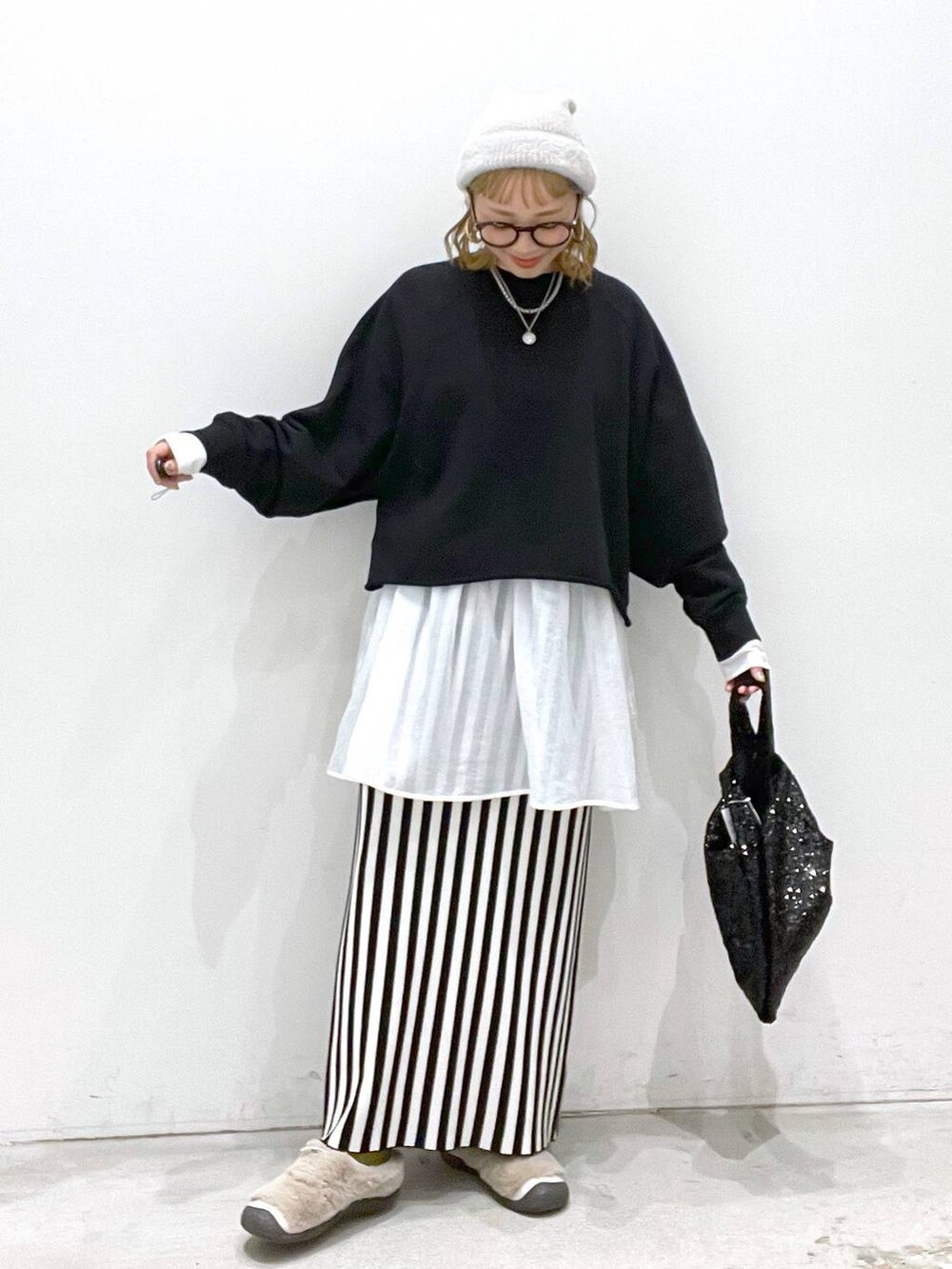 ブラック系のスカート、ブラック系のTシャツ/カットソー、ホワイト系のTシャツ/カットソーを着用したレディースの秋コーディネートの4枚目の写真