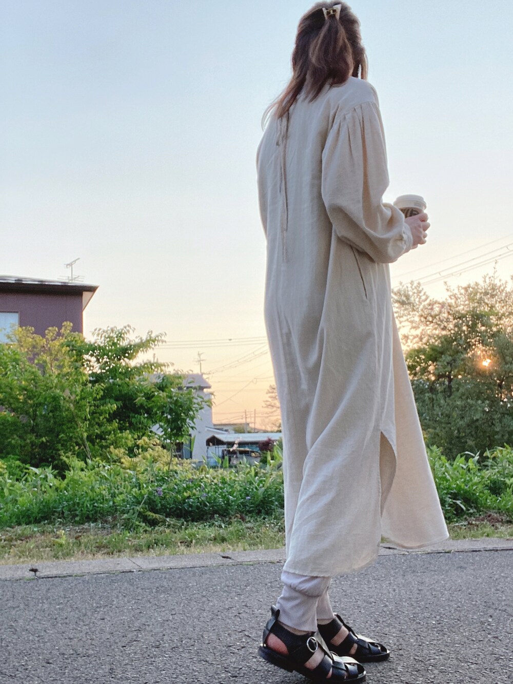 ブラック系のサンダル、ゴールド系のメガネを着用したレディースの春コーディネートの2枚目の写真