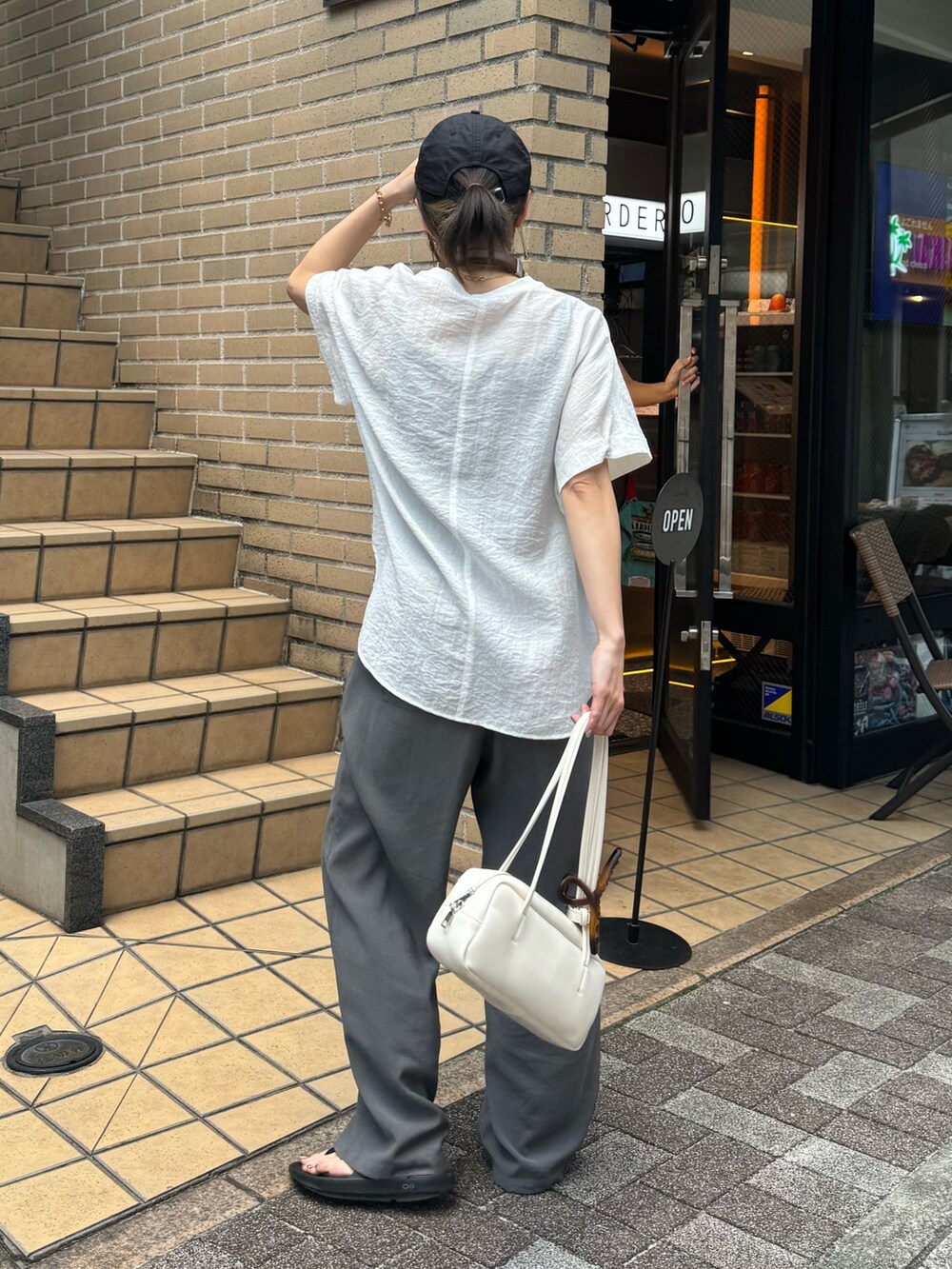 ホワイト系のシャツ/ブラウス、グレー系のサンダル、グレー系のスラックスを着用したレディースの夏コーディネートの4枚目の写真
