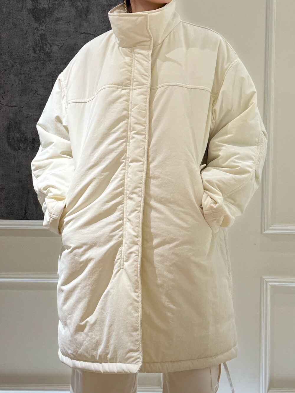 ホワイト系のカーゴパンツ、ブラック系のブーツ、パープル系のニット/セーターを着用したレディースの冬コーディネートの3枚目の写真