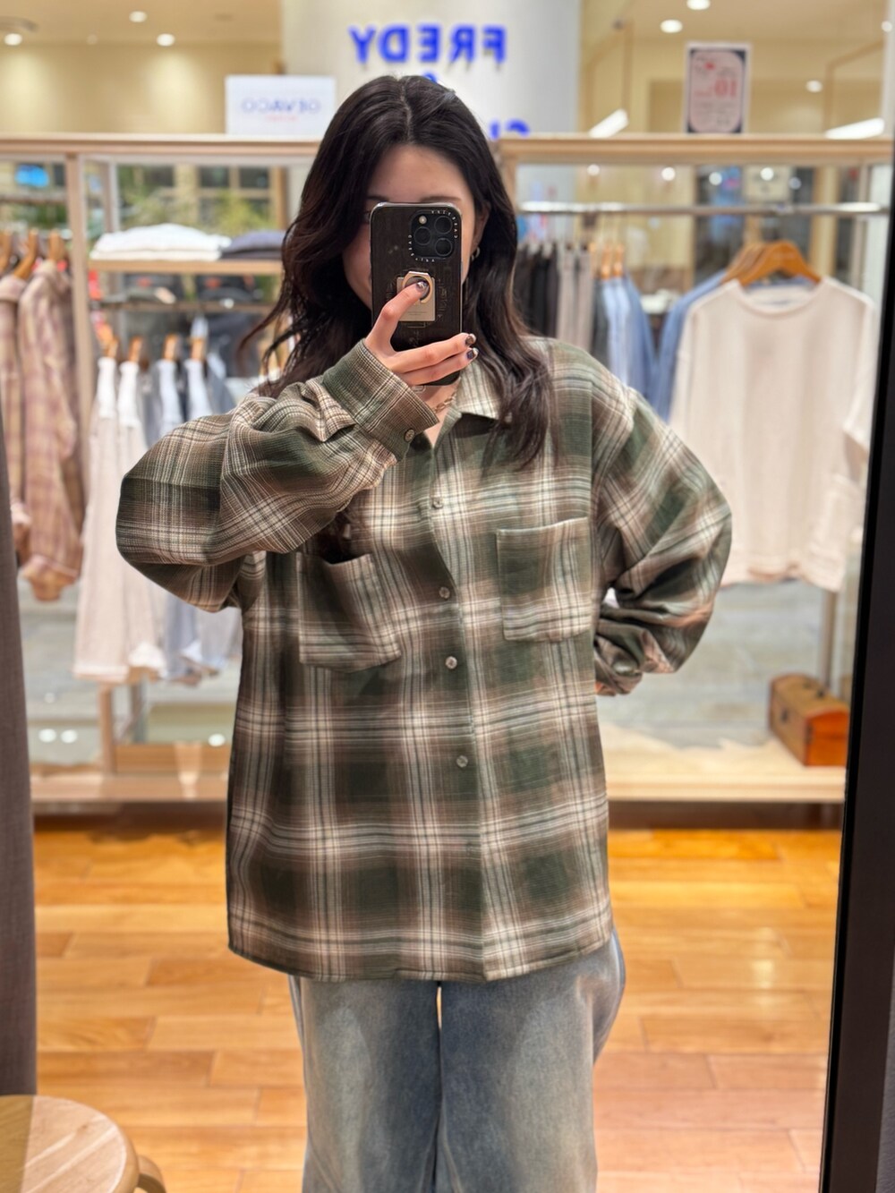 グリーン系のシャツ/ブラウス、ブルー系のデニムパンツを着用したレディースの秋コーディネートの2枚目の写真