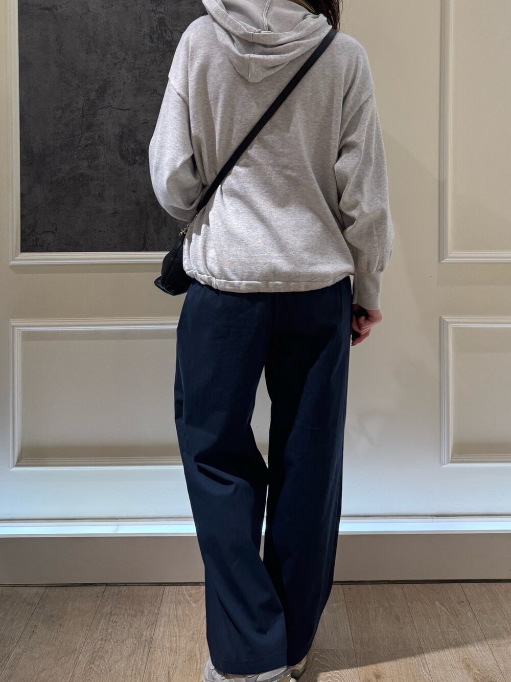 グレー系のニット/セーター、ブラック系のショルダーバッグ、ブルー系のその他パンツを着用したレディースの春コーディネートの5枚目の写真