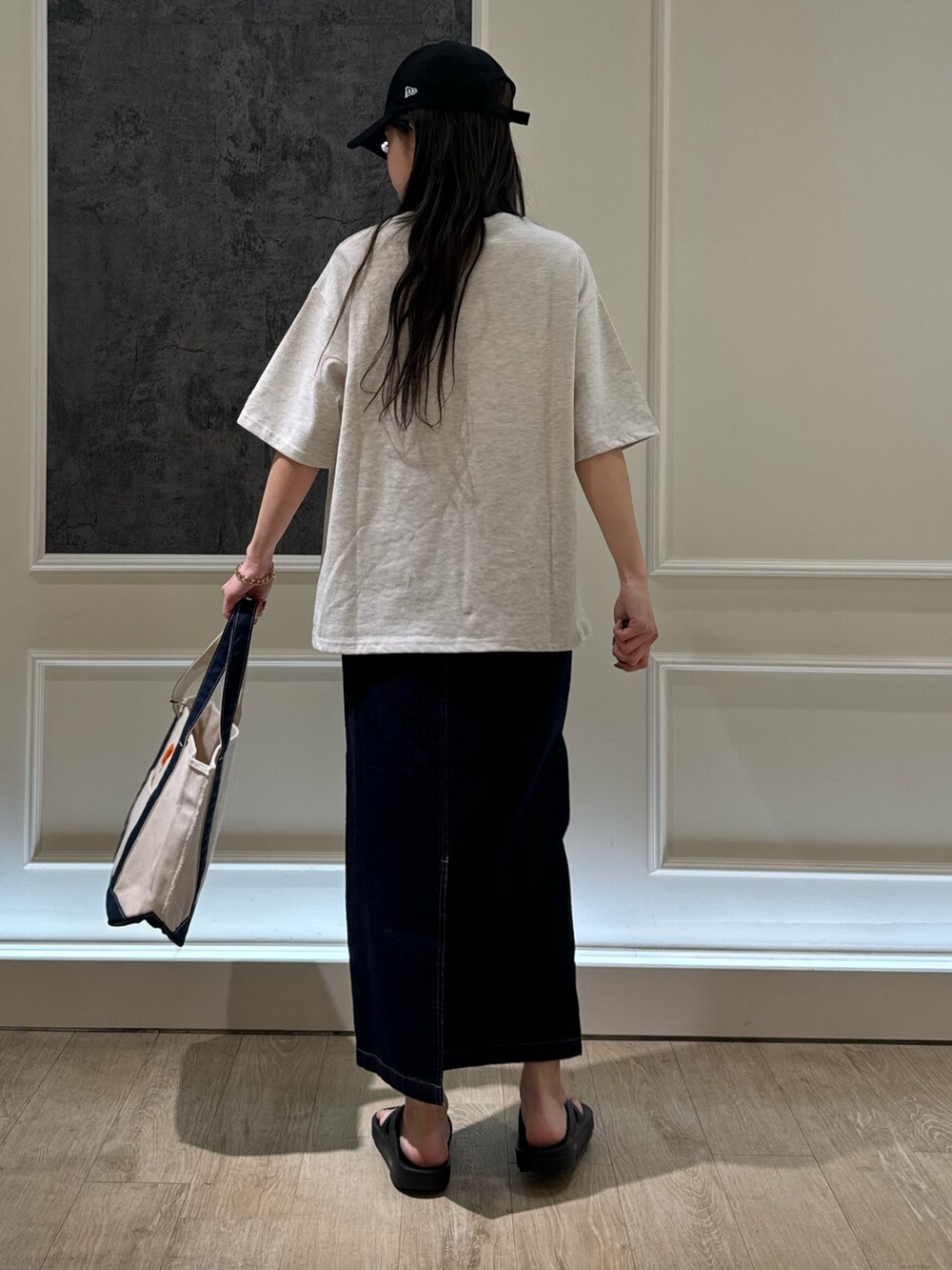 ベージュ系のTシャツ/カットソー、ブルー系のデニムスカート、ブラック系のトートバッグを着用したレディースの春コーディネートの3枚目の写真