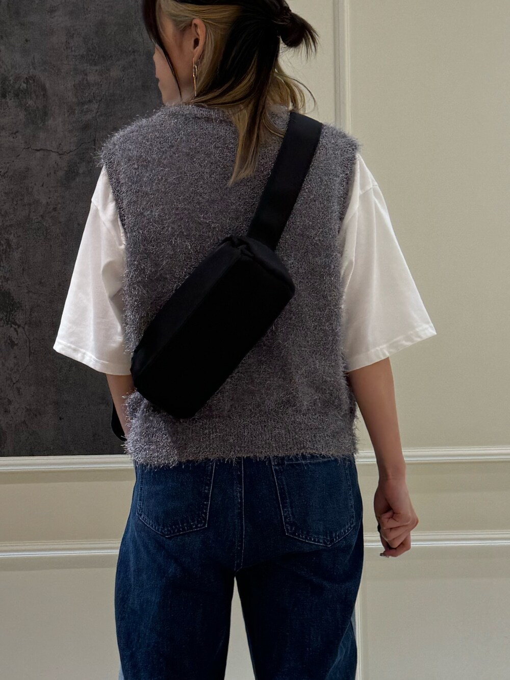 ブルー系のデニムパンツ、グレー系のベスト、ブラック系のショルダーバッグを着用したレディースの夏コーディネートの4枚目の写真