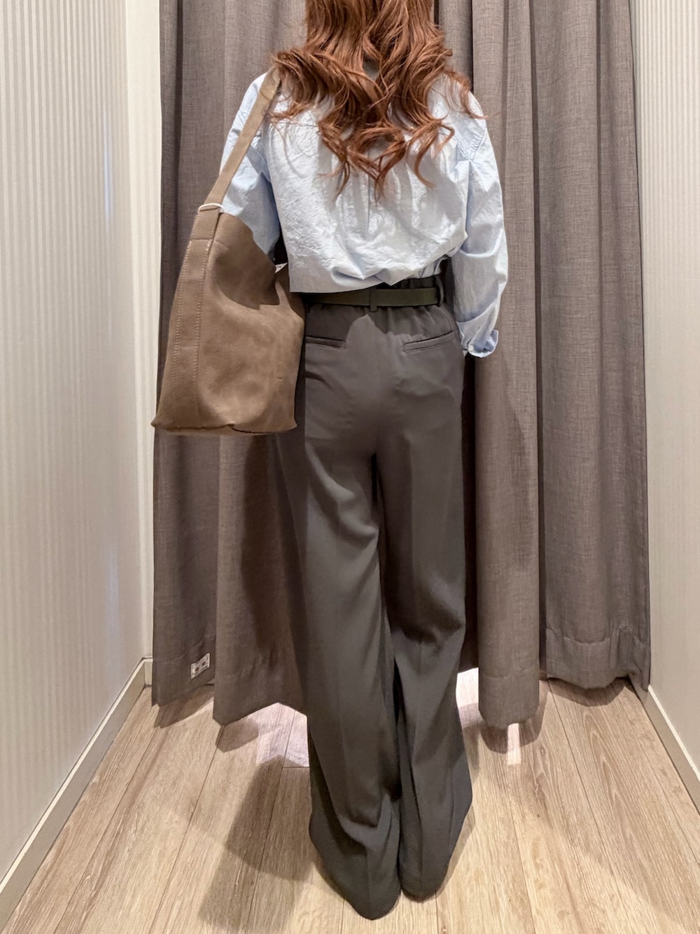 ブルー系のシャツ/ブラウス、ベージュ系のショルダーバッグ、グレー系のスラックスを着用したレディースの春コーディネートの3枚目の写真