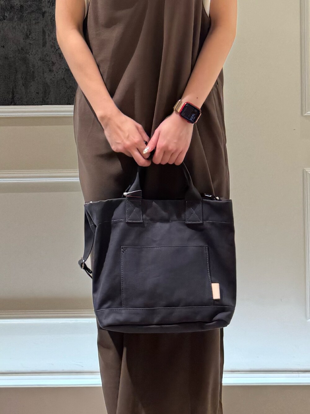 ブラウン系のワンピース、ブラック系のトートバッグ、シルバー系のサンダルを着用したレディースの夏コーディネートの4枚目の写真