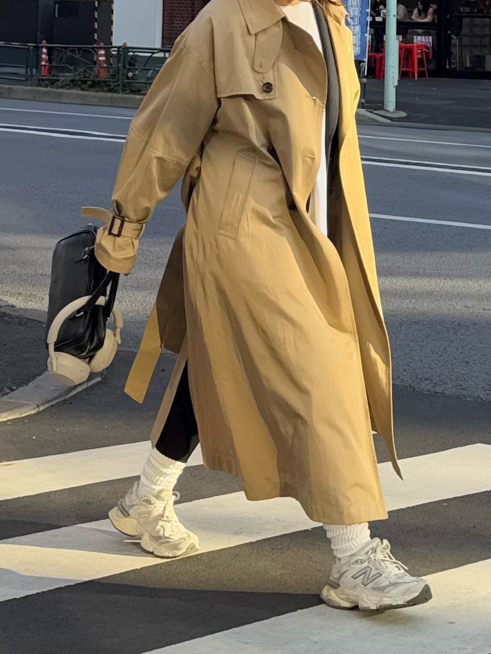 ベージュ系のトレンチコート、ブラック系のハンドバッグを着用したレディースの冬コーディネートの5枚目の写真