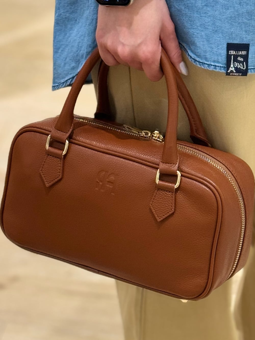 ブルー系のシャツ/ブラウス、ベージュ系のチノパンツ、イエロー系のショルダーバッグを着用したレディースの春コーディネートの4枚目の写真