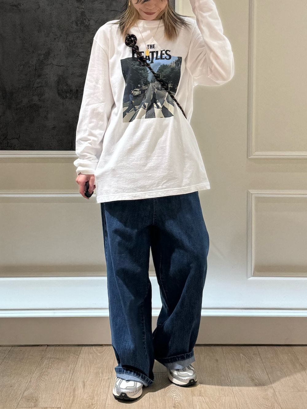 ホワイト系のTシャツ/カットソー、ブルー系のデニムパンツ、ブラック系のショルダーバッグを着用したレディースの秋コーディネートの3枚目の写真