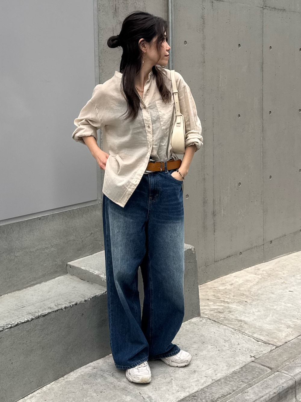 ベージュ系のシャツ/ブラウス、ブルー系のデニムパンツを着用したレディースの春コーディネートの6枚目の写真