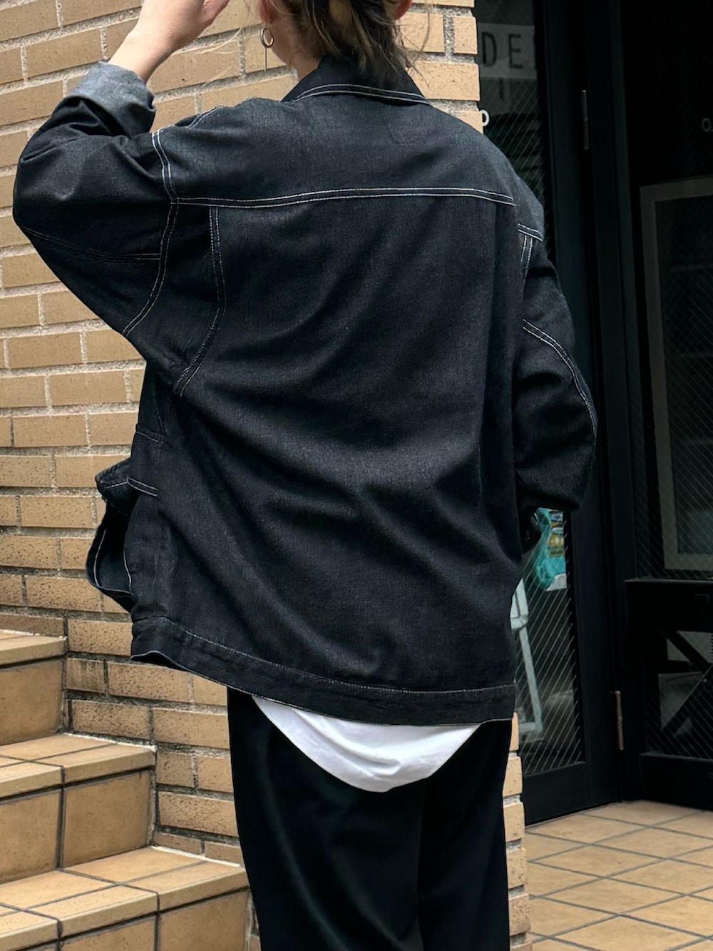 ブラック系のブルゾン、ホワイト系のTシャツ/カットソーを着用したレディースの秋コーディネートの3枚目の写真