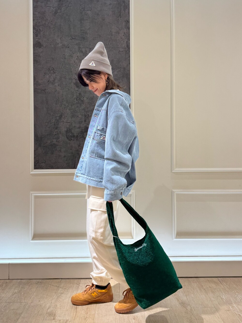 ブルー系のデニムジャケット、オレンジ系のトートバッグ、ホワイト系のカーゴパンツを着用したレディースの冬コーディネートの4枚目の写真