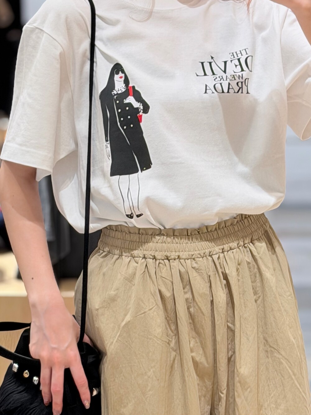 ホワイト系のTシャツ/カットソー、ベージュ系のその他パンツ、ベージュ系のショルダーバッグを着用したレディースの夏コーディネートの2枚目の写真
