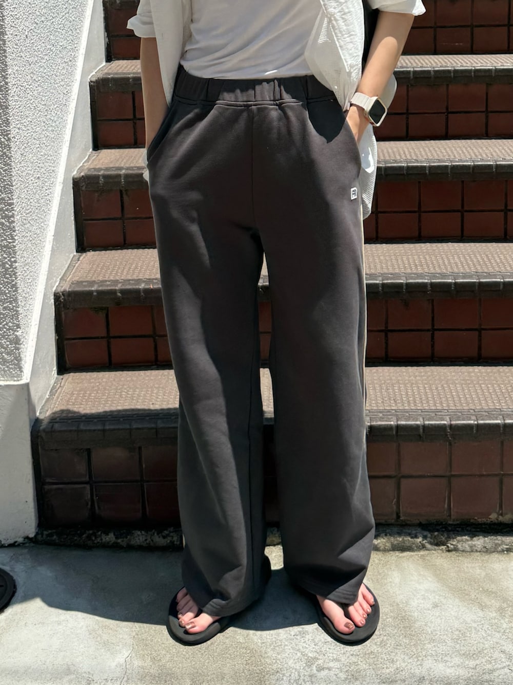 ベージュ系のシャツ/ブラウス、グレー系のスウェットパンツ、グレー系のサンダルを着用したレディースの夏コーディネートの5枚目の写真