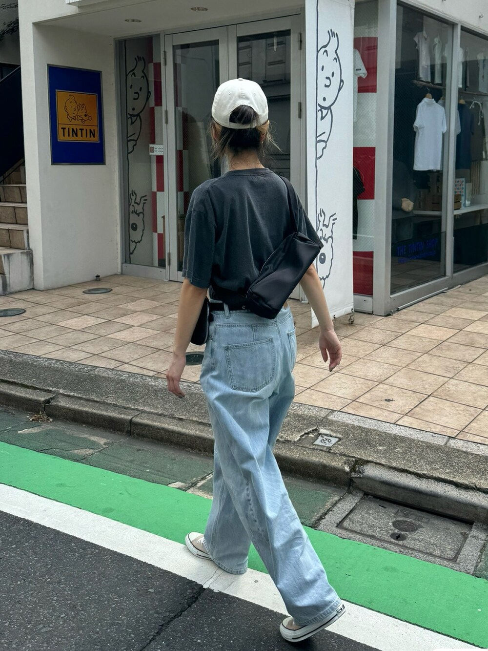 グレー系のTシャツ/カットソー、ブルー系のデニムパンツ、ブラック系のショルダーバッグを着用したレディースの夏コーディネートの3枚目の写真