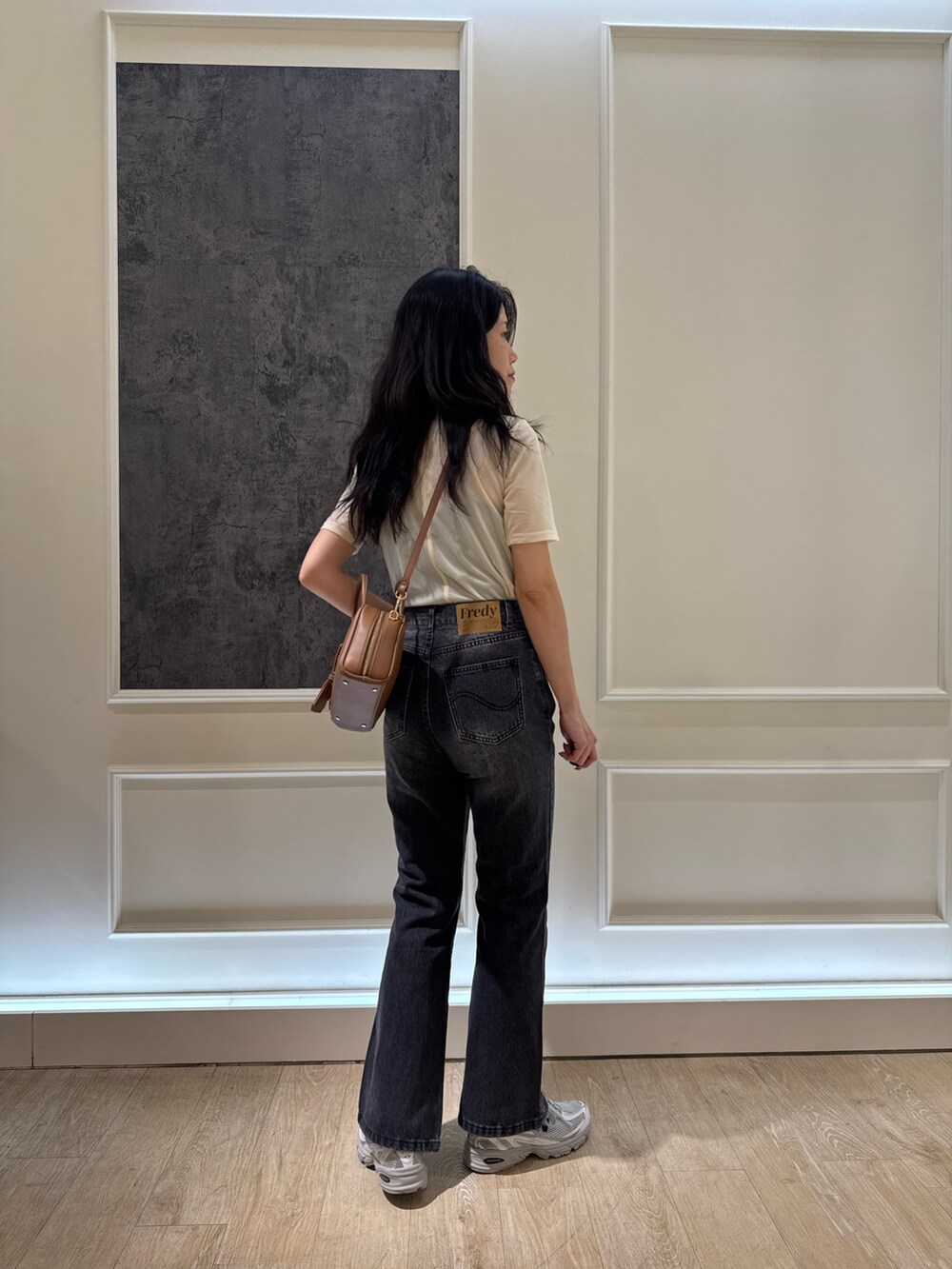 ベージュ系のTシャツ/カットソー、ブラック系のデニムパンツ、イエロー系のショルダーバッグを着用したレディースの夏コーディネートの2枚目の写真