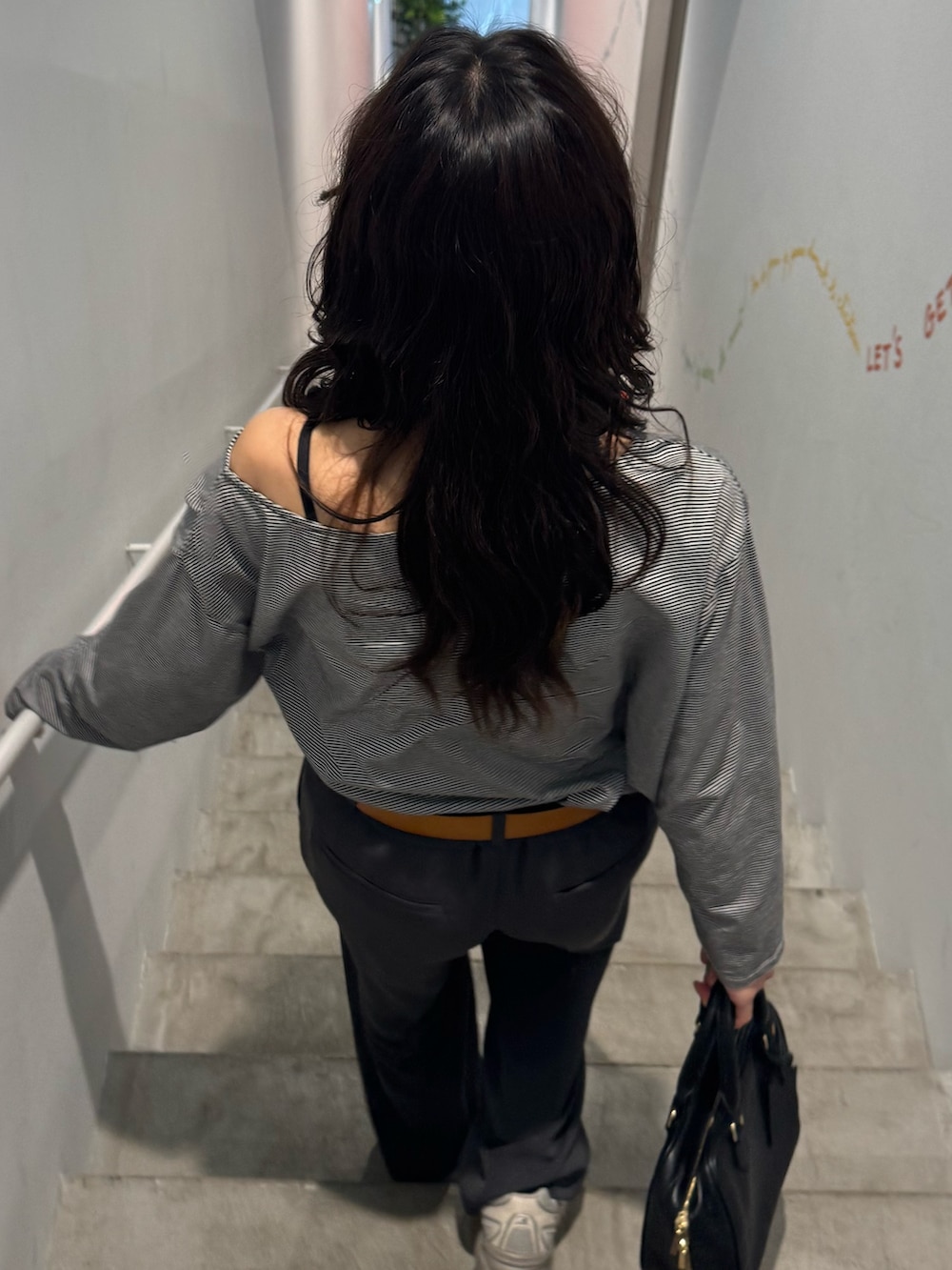 ホワイト系のTシャツ/カットソー、ブラック系のスラックスを着用したレディースの春コーディネートの3枚目の写真