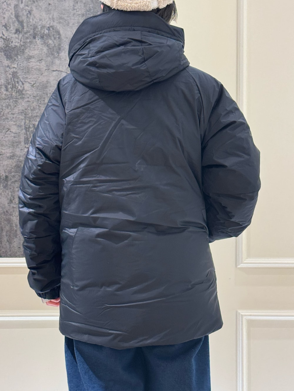 ブラック系のスウェット、ブラック系のダウンジャケット/コート、ブルー系のデニムパンツを着用したレディースの冬コーディネートの4枚目の写真