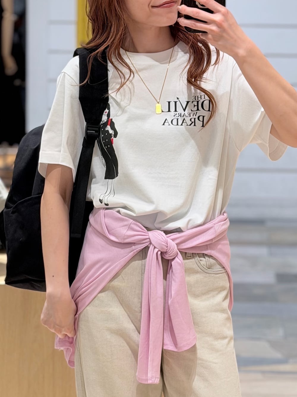 ホワイト系のTシャツ/カットソー、ベージュ系のデニムパンツ、ブラック系のバックパック/リュックを着用したレディースの夏コーディネートの3枚目の写真