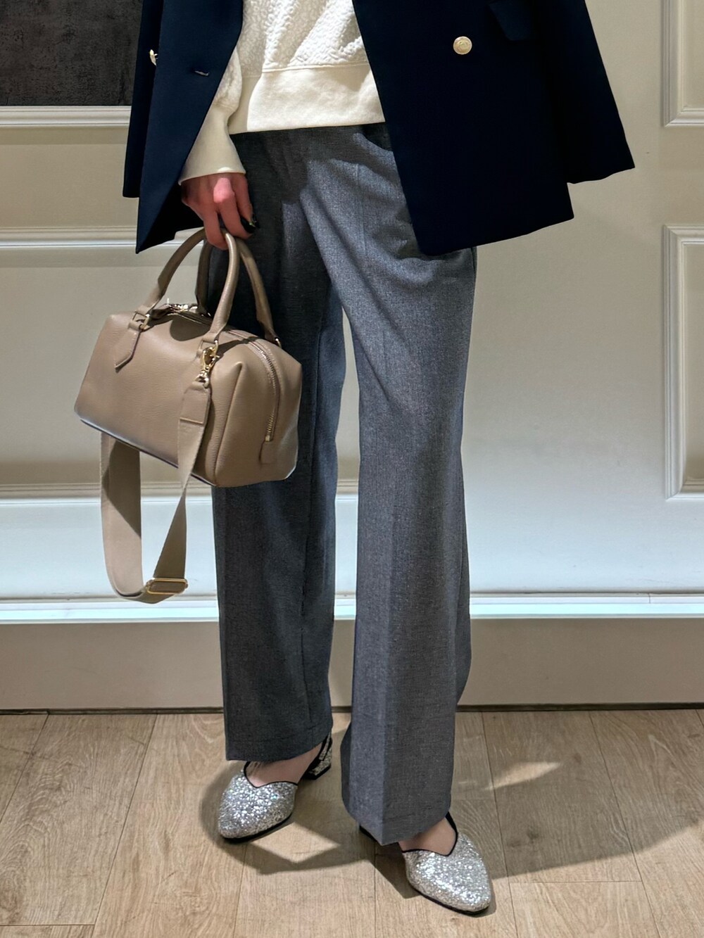 ブルー系のテーラードジャケット、ベージュ系のボストンバッグ、ブルー系のスラックスを着用したレディースの春コーディネートの3枚目の写真