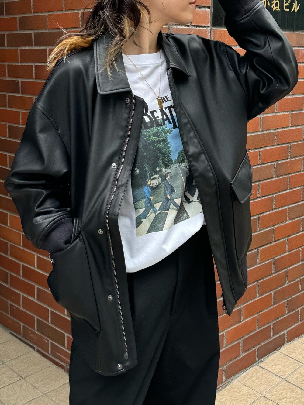 ブラック系のブルゾン、ホワイト系のTシャツ/カットソーを着用したレディースの秋コーディネートの2枚目の写真
