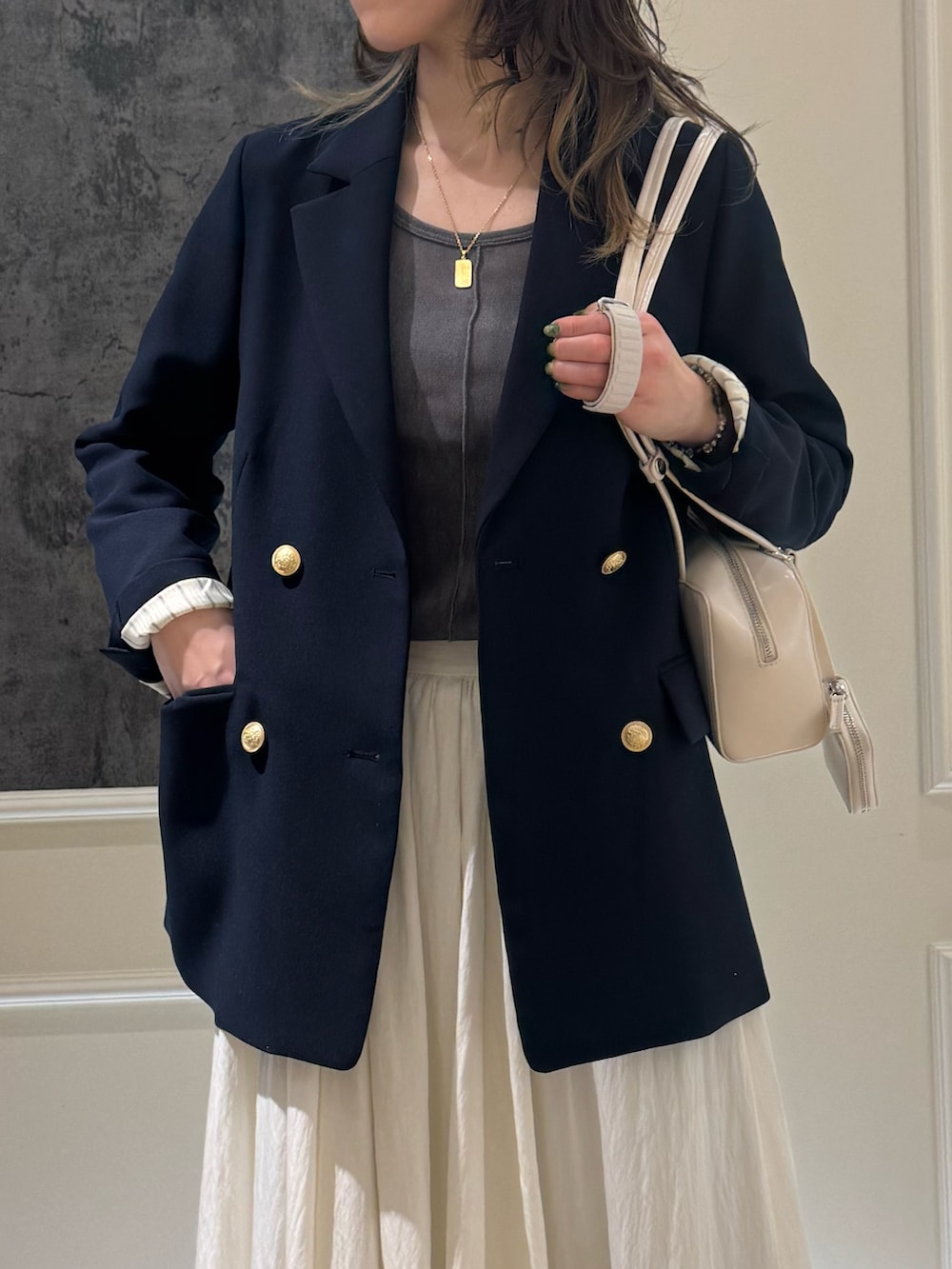 ブルー系のテーラードジャケット、グレー系のTシャツ/カットソー、ホワイト系のスカートを着用したレディースの春コーディネートの2枚目の写真