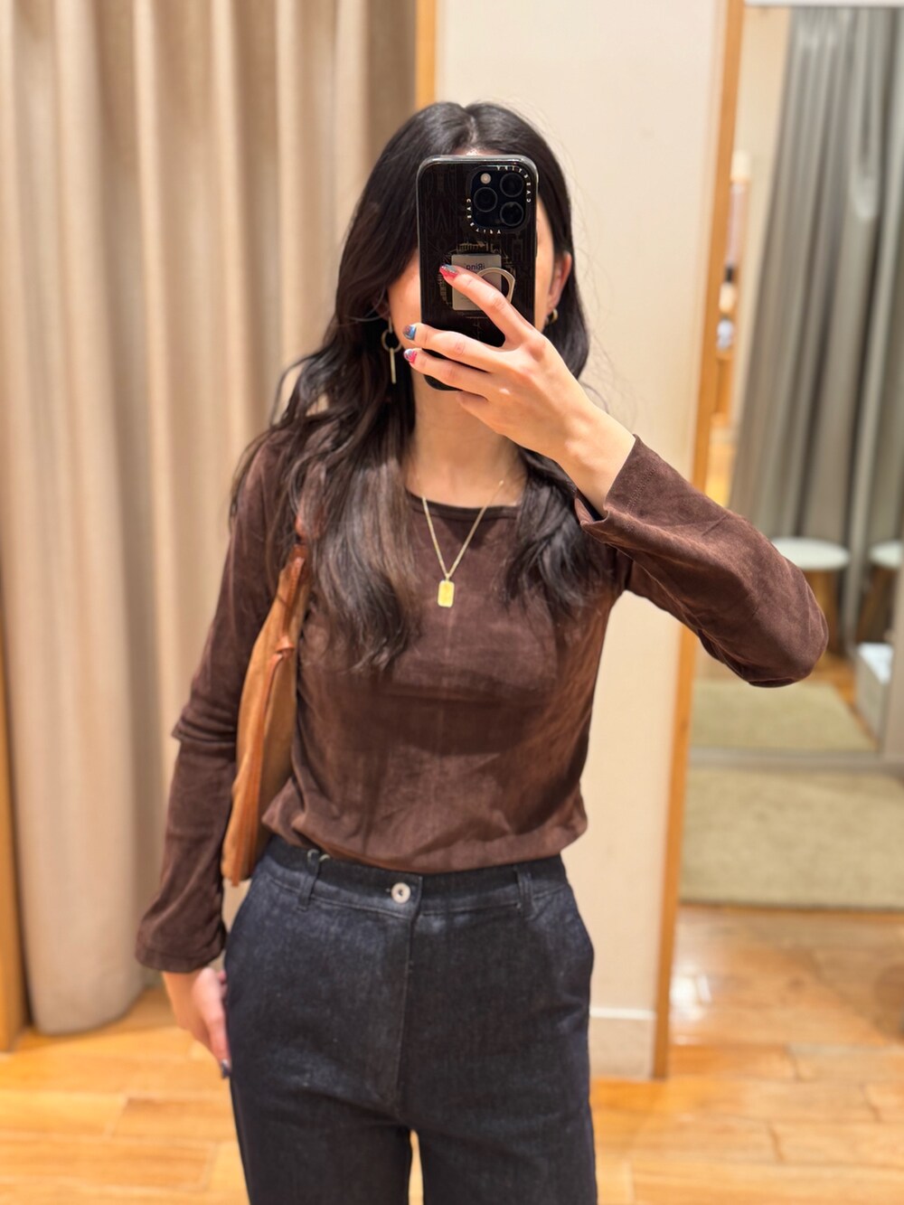 ブラウン系のTシャツ/カットソー、ブルー系のデニムパンツを着用したレディースの秋コーディネートの2枚目の写真